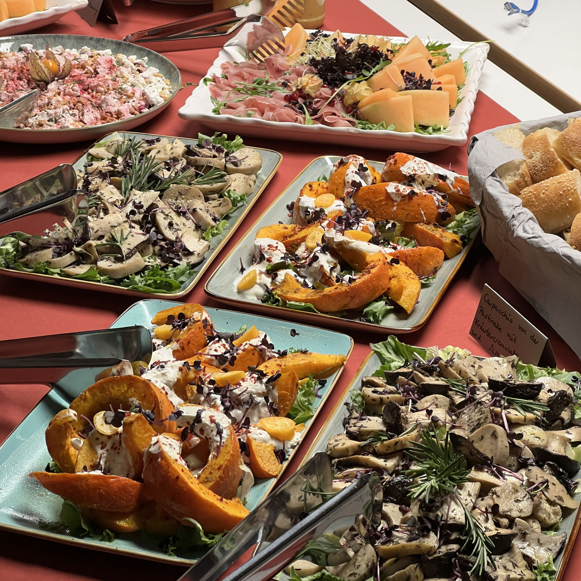 Bunte Salatvariationen, Kürbisgerichte, Melonen und Dressings auf festlichem Tisch.