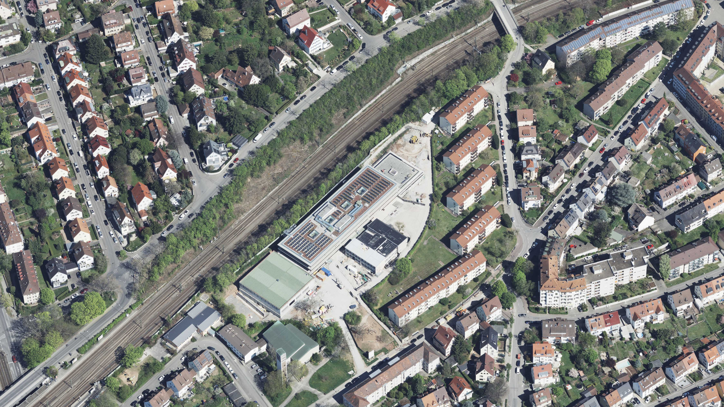 Luftbild der Schule inklusive der umliegenden Bebauung und der Bahnstrasse.